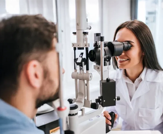 A doctor using diagnostic tools to examine a male patient's eyes